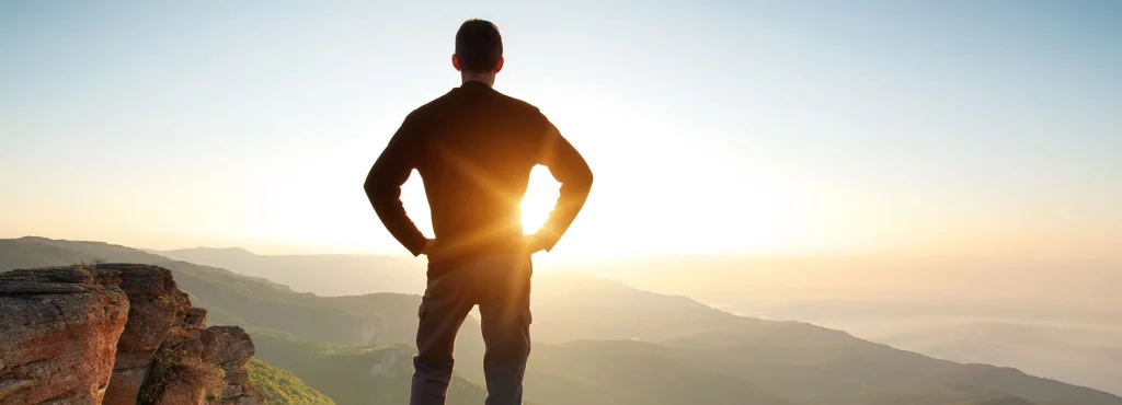 Hiker looking out over the sunset in the mountains