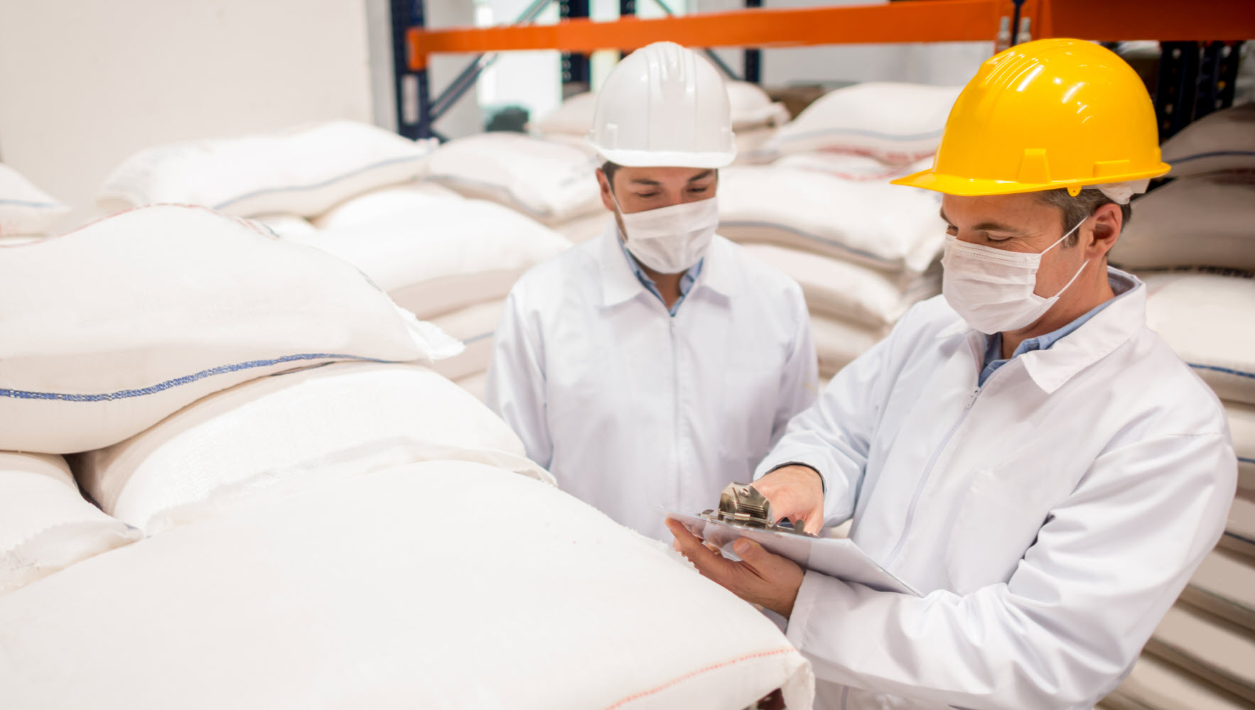 Workers in hardhats wearing protective masks