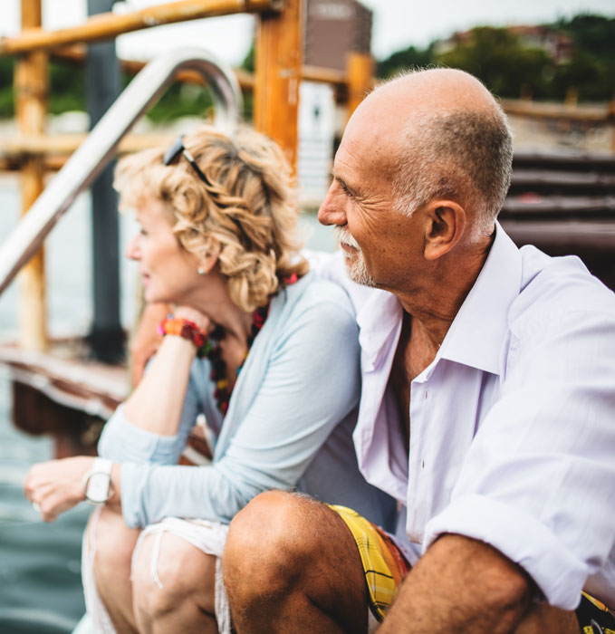 Man and lady sitting on a dock