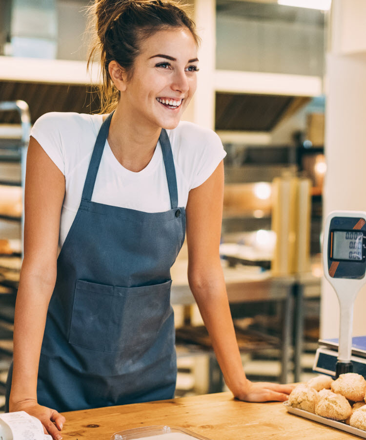 Smiling woman behind bakery counter