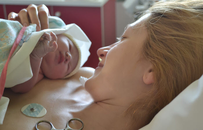 Mother holding newborn on her chest