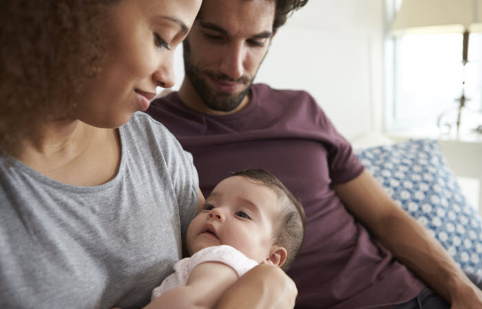 Young couple cuddling baby