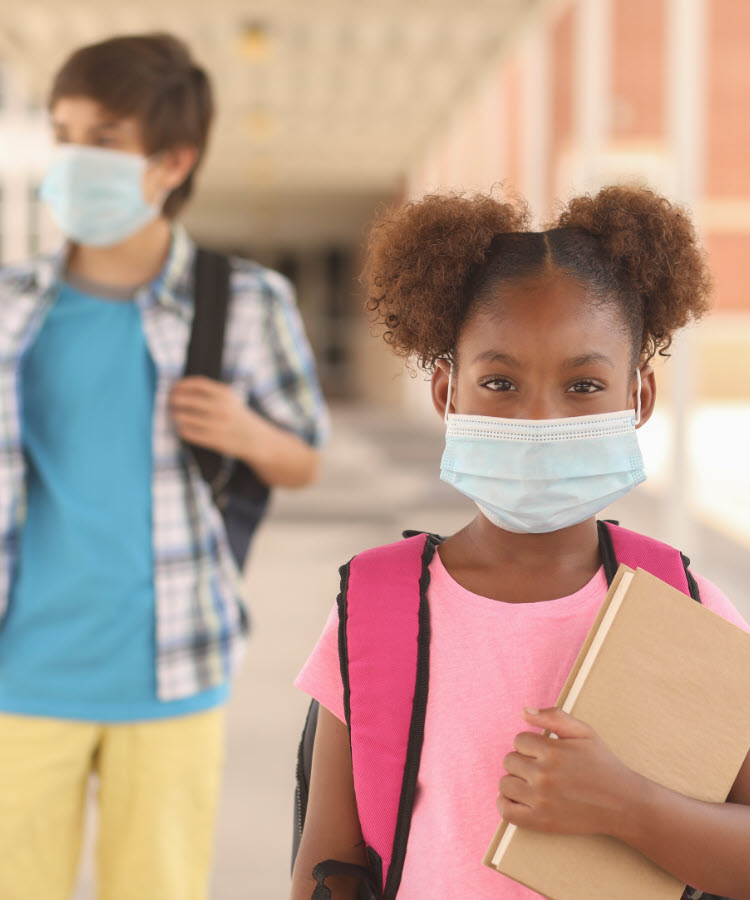 Two schoolkids wearing masks