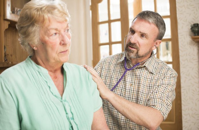 Provider with stethoscope examining older woman