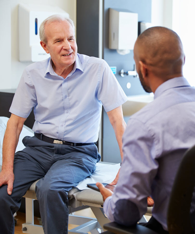 Physician conferring with older male patient