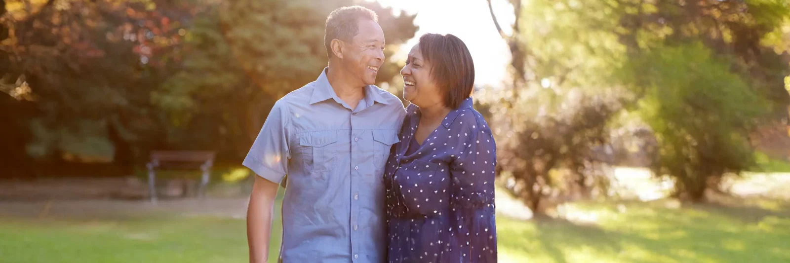 Pareja feliz en el parque luego de recibir tratamiento en UCHealth para la esclerosis múltiple.