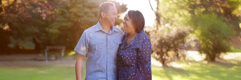 Pareja feliz en el parque luego de recibir tratamiento en UCHealth para la esclerosis múltiple.