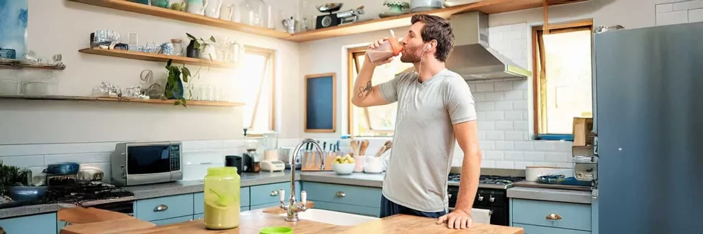 UCHealth Today dietary supplements. Man in kitchen taking supplements.