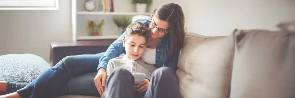 UCHealth limit kids screen time. Mom and child playing on a phone together.