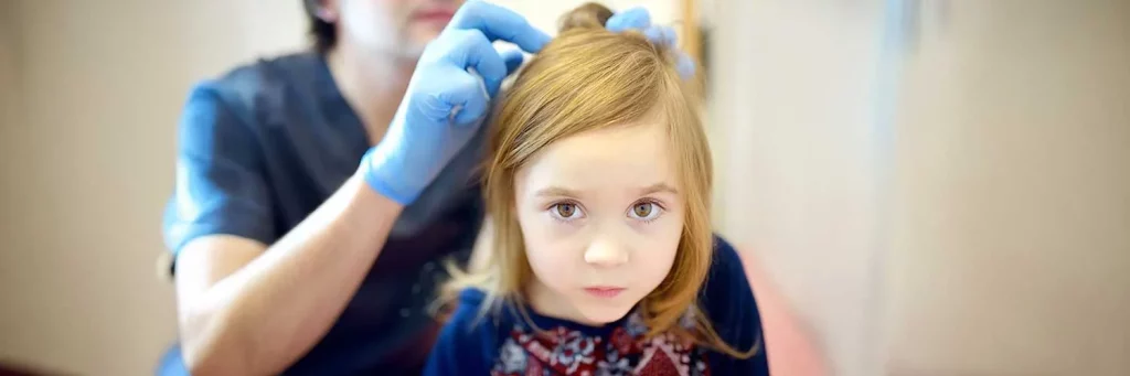 UCHealth today all about bugs, young girl being checked for lice.