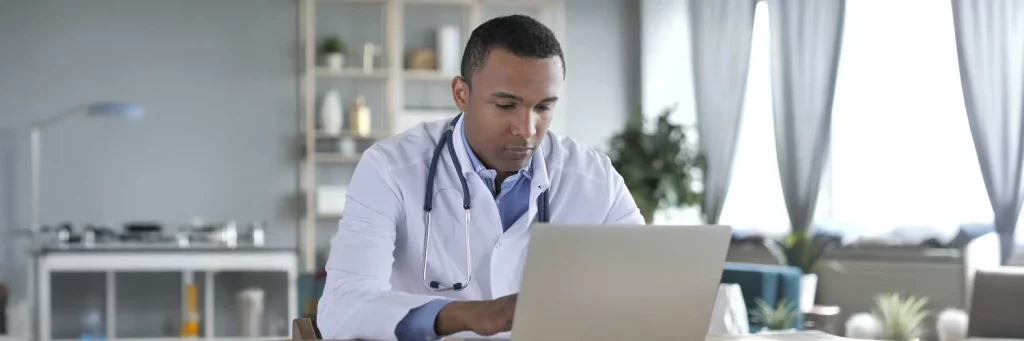 UCHealth Virtual Monitoring. Doctor chatting with patient over computer.