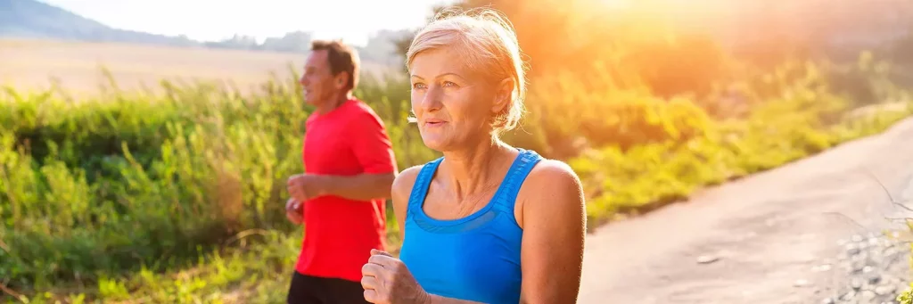 UCHealth innovative approach to joint replacment. Older couple power walking on paved path.