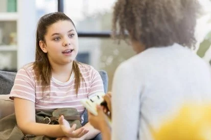 UCHealth Healthy Hearts and Minds behavioral health. Teen speaking with counselor.