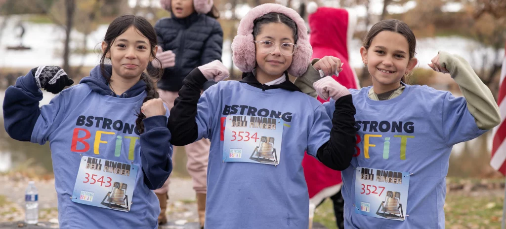 UCHealth Healthy Hearts and Minds Bstrong Bfit elementary aged girls making muscles and smiling.