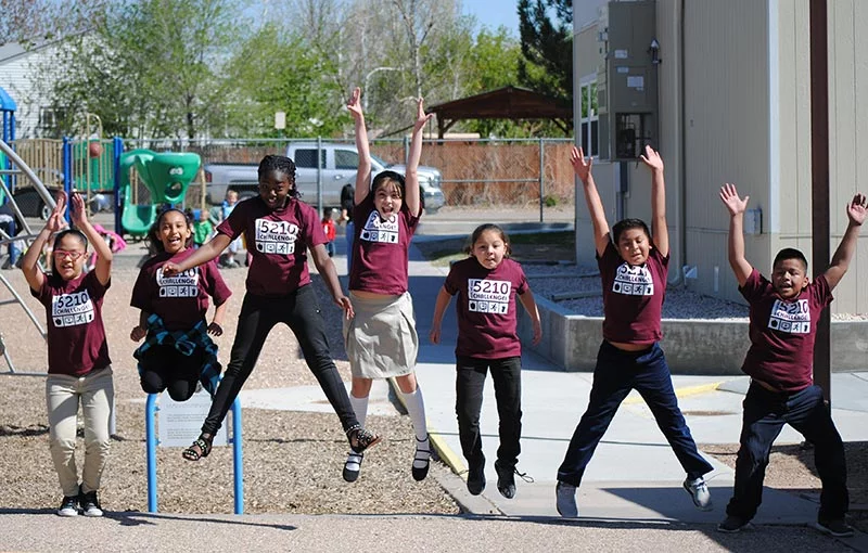 UCHealth Healthy Hearts Healthy Minds teaching kids healthy habits. Kids jumping on playground.