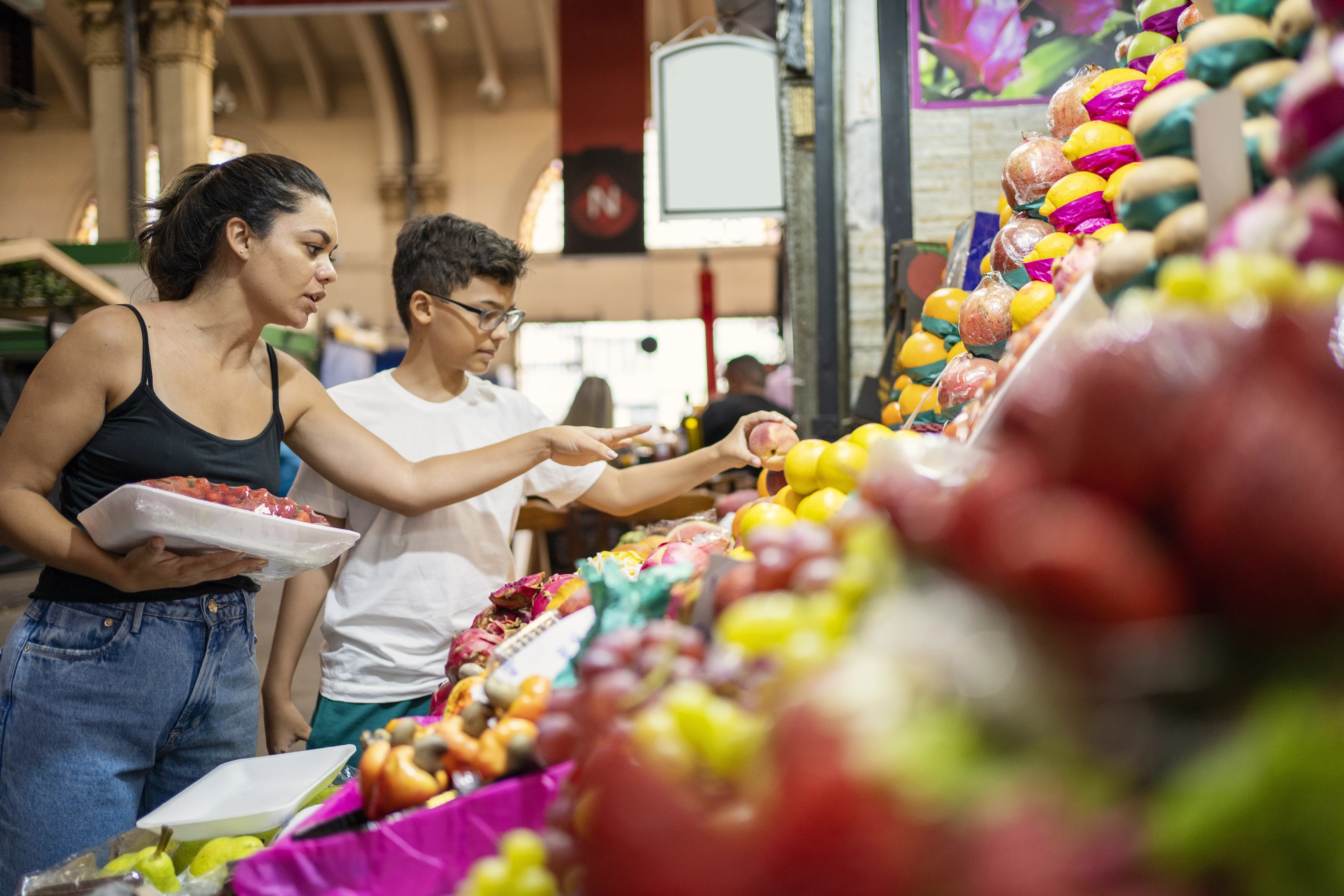 UCHealth Healthy Hearts and Minds Family Program. Mother and son choosing fruit at the farmers market.