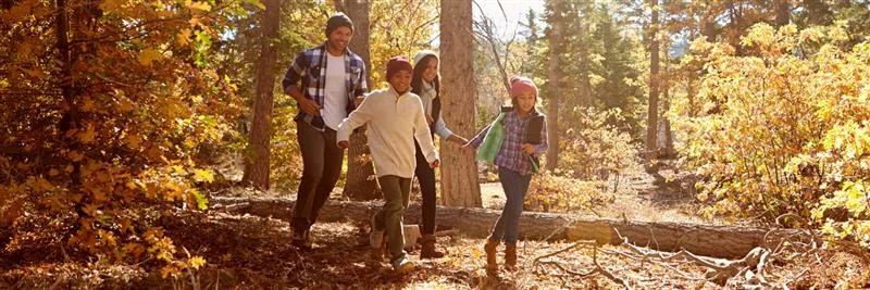 Familia de UCHealth Community Health caminando por el bosque.