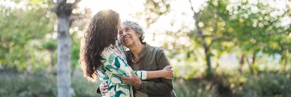 UCHealth mother and daughter hugging and smiling in the park