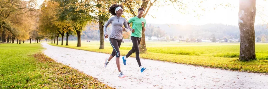 UCHealth Transplant services. Couple running on trail in a park.