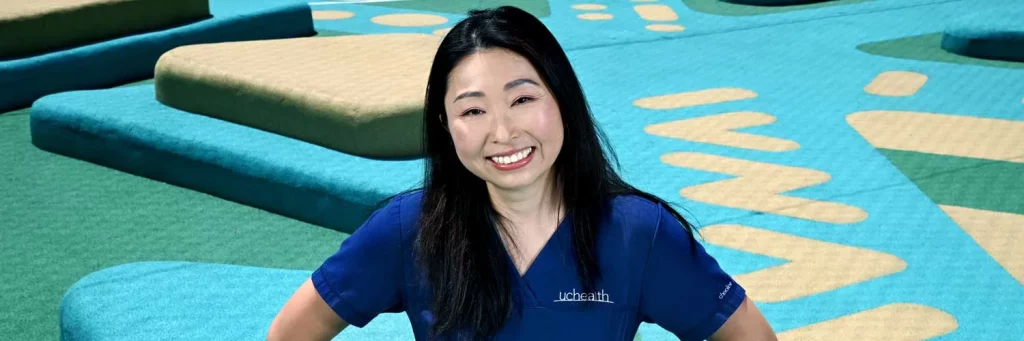 UCHealth connecting with a patient to deescalate a behavioral health crisis. Nurse smiling at camera.