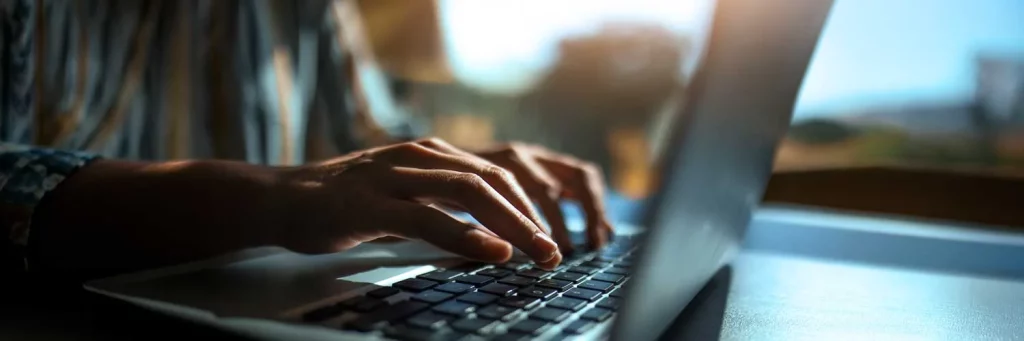 UCHealth improving the inpatient RN recruitment process. Hands typing on a keyboard.