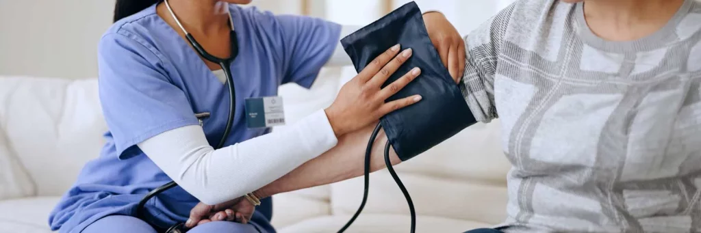 UCHealth ensuring patients are fully prepared for discharge from the ED. Nurse adjusting blood pressure cuff on patient's arm.