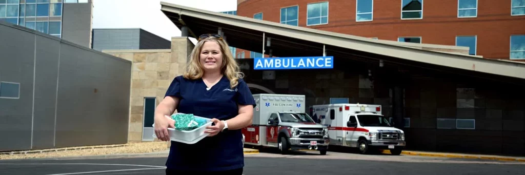UCHealth expanding support for families navigating pregnancy loss in emergency care. Nurse standing outside in front of ambulance bay.