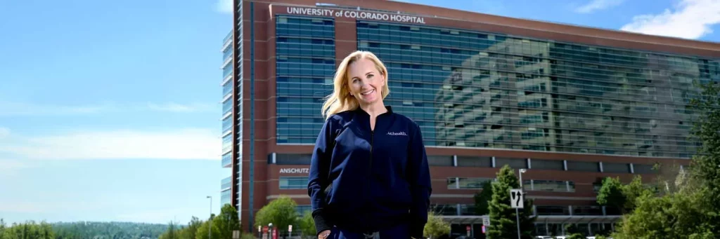 UCHealth Supporting staff and patients through enhanced safety response processes. Nurse standing in front of University of Colorado Hospital.