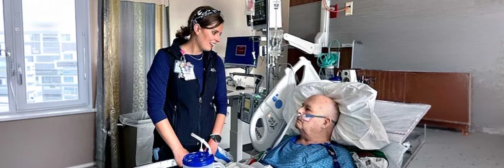 UCHealth fesity at heart patient. Nurse standing at bedside of patient and talking with them.