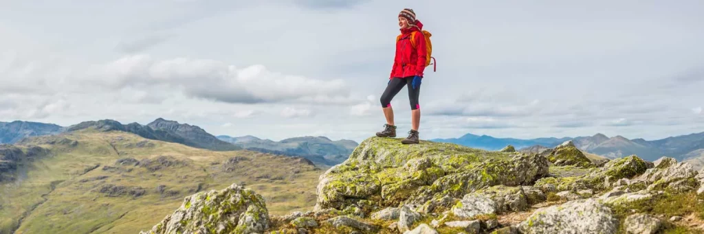 About nursing at UCHealth. Woman standing on mountain.