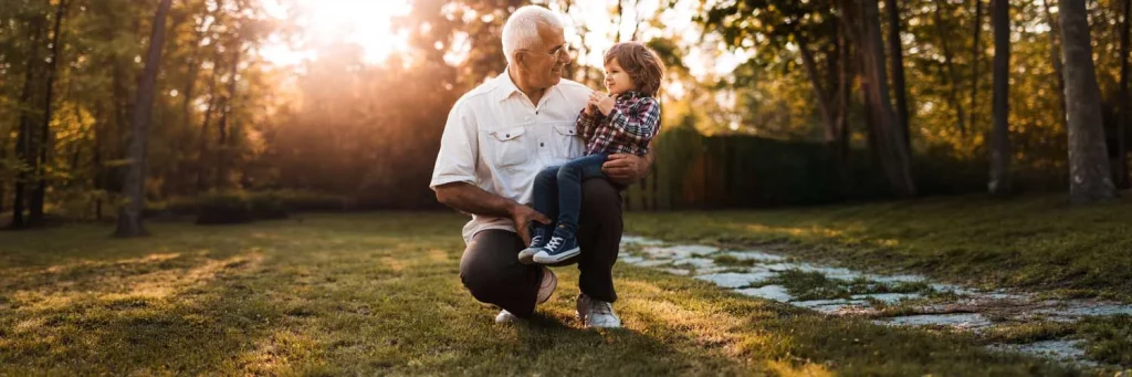 Cuidado ocular ucraniano, cataratas. Abuelo sosteniendo al nieto mientras juega en el jardín.