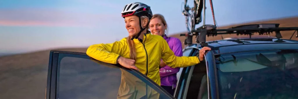 UCHealth Lasik, women smiling at car after a bike ride.