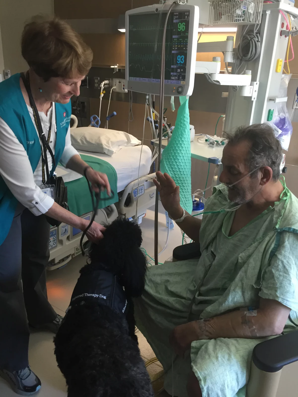 UCH volunteer Alice Jensen and her dog Ebony cheer up patient Anthony Troutner.