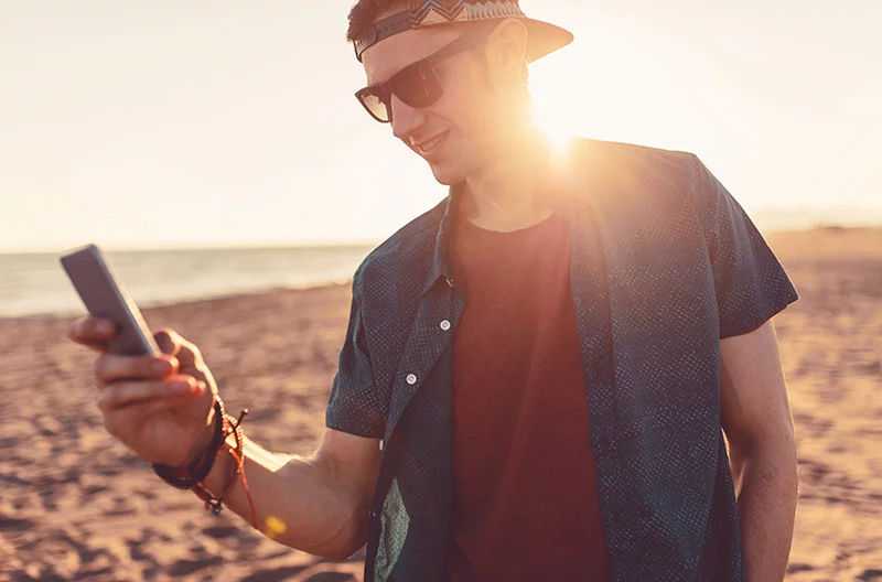 man looking at his phone during his PokeMaster journey.