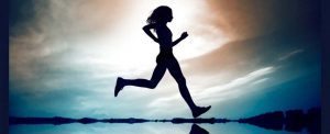 a woman running with light and a sky behind her