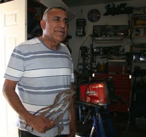 A portrait of Flores with his welding work.