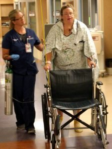 Registered nurse Kerry Minster, a cardiovascular intensive care nurse at UCHealth Medical Center of the Rockies, helps Veronica Wilkins recover from her emergency C-section and open-heart surgery.