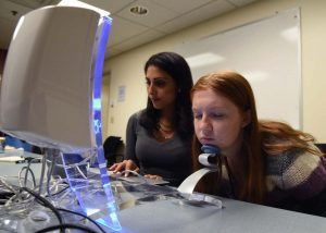 Elsa Weltzien, a project team member, poses for the Reveal Imager as Jessica Mounessa runs the machine.