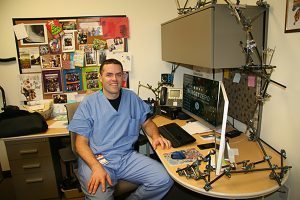 An orthopedic surgeon poses at his desk.