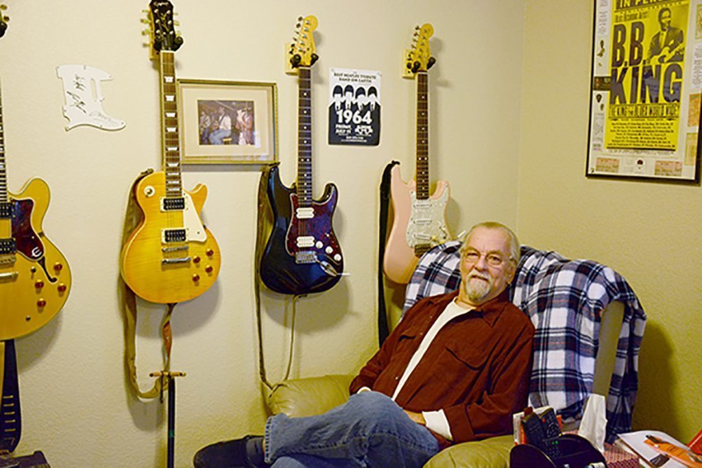 Martin Gordon of the West Side Rhythm Kings in his “man cave’ with several guitars at his home in Colorado Springs.