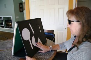 A patient uses a magnetic board to practice using the bionic eye.