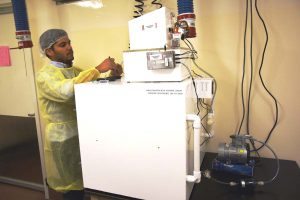 Ivan Rodriguez, MD, a professional research assistant with the CU School of Medicine, prepares an e-cigarette for the smoking machine.