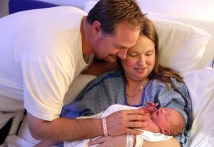 mom and dad holding newborn
