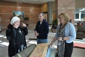 three people look at fabric