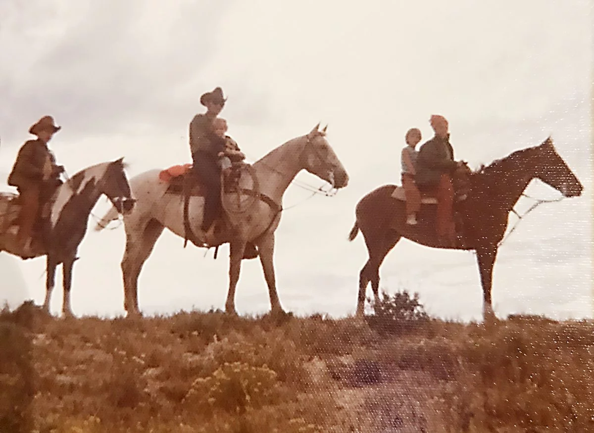 O. Rex Story and his four children are shown on horses along the Laramie River.