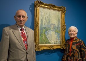 Morton Mower, MD and his wife, Tobie Mower, are pictured in front of a painting by Claude Monet.