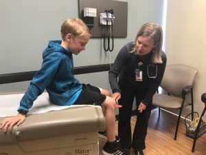 Monica Lederman, a physician assistant, provides a physical for her son, Caleb, 9. UCHealth is currently offering $30 physicals at all Urgent Care locations.