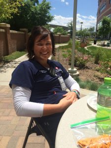 Rachel Kuker, a UCHealth nurse, sits outside in her scrubs. She joined a team of volunteers in Texas.