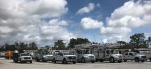 A fleet of white SUVs wait on a highway to get the go-ahead to drive on flooded highways to Miami after Hurricane Irma. Blue skies show above the SUVs, a sign that the storm has passed.