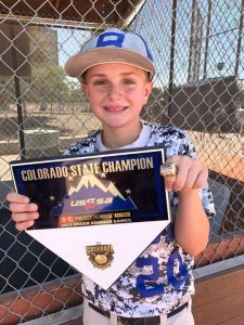 Brayden Tate holding championship trophy after a broken thumb.
